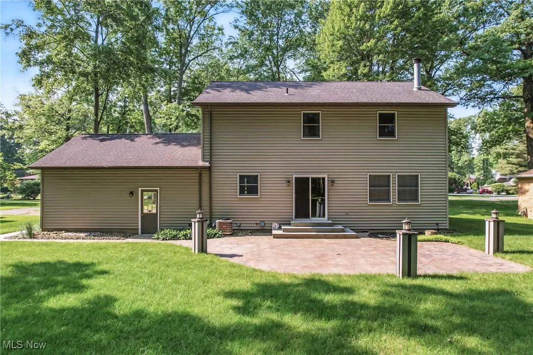 Rear view of house with a patio area and a lawn