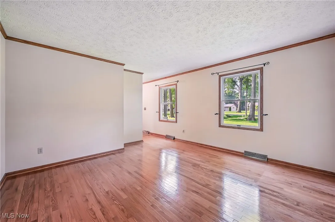 Living room with crown molding, wood finished floors, and baseboards