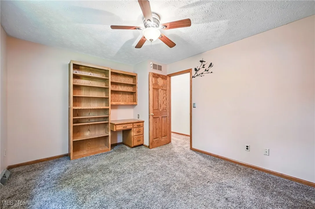Bedroom with built in book shelves and desk
