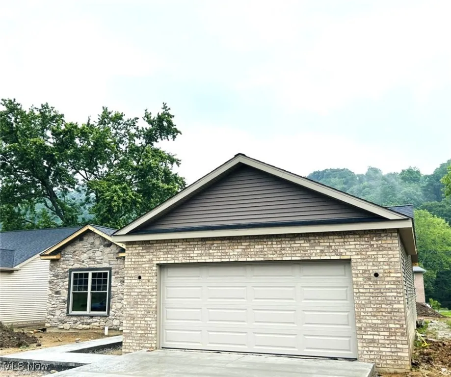 Ranch-style house with an attached garage, driveway, and brick siding