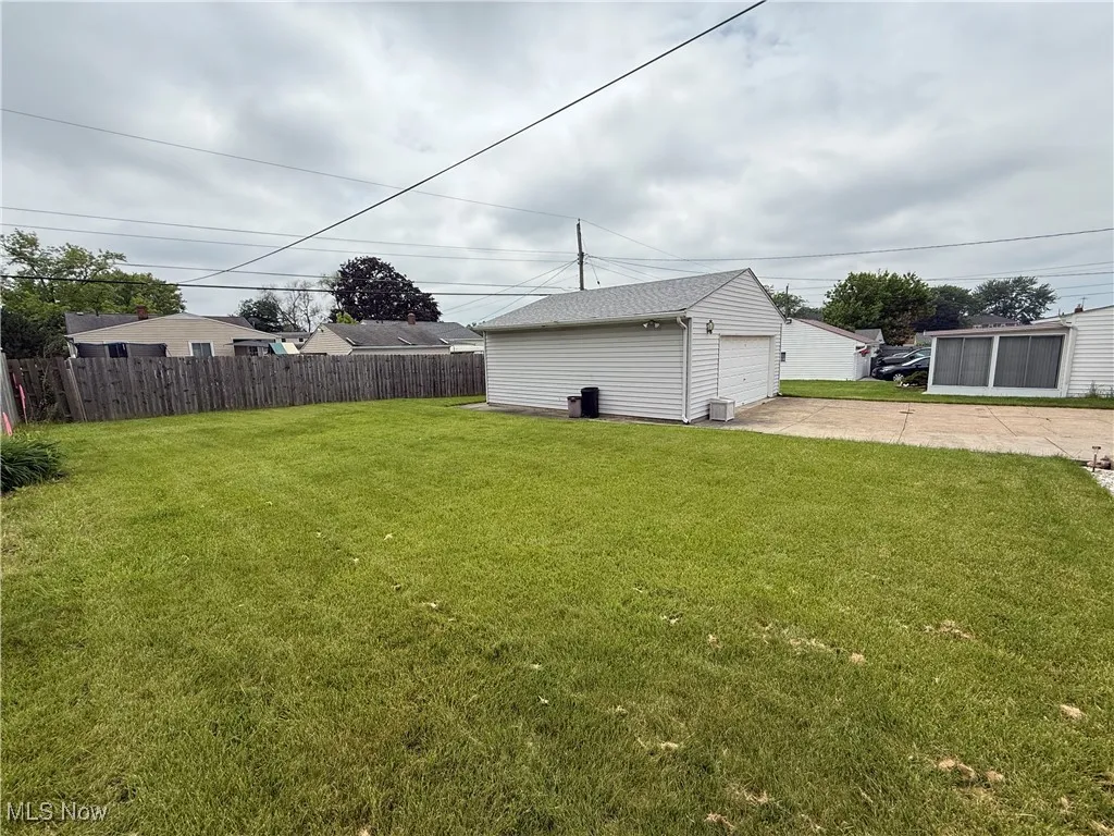View of yard featuring driveway, an outdoor structure, and a garage