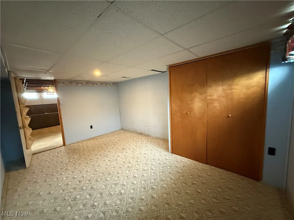 Unfurnished bedroom with a paneled ceiling and a closet