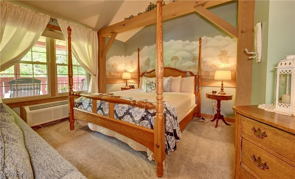 Bedroom featuring carpet and lofted ceiling