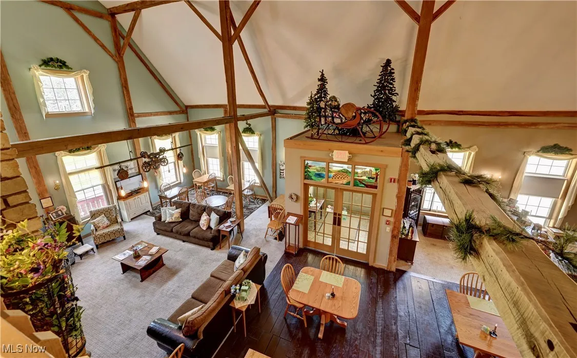 Living area with a towering ceiling and hardwood / wood-style floors