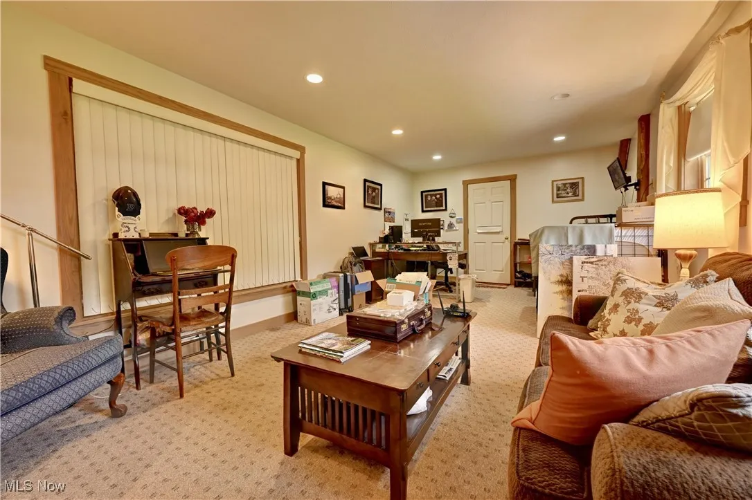 Living area with light colored carpet, recessed lighting, and an office area