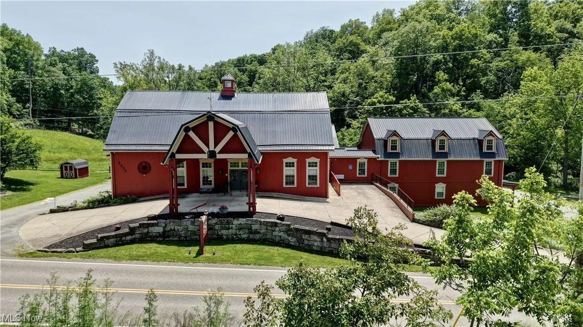 View of front facade featuring metal roof, a chimney, and a front yard