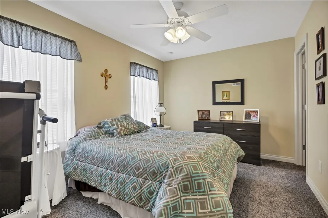 Bedroom with carpet flooring, baseboards, and a ceiling fan