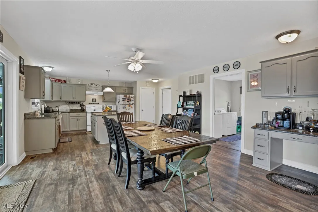 Dining space featuring a ceiling fan, dark wood-style floors, independent washer and dryer, and baseboards