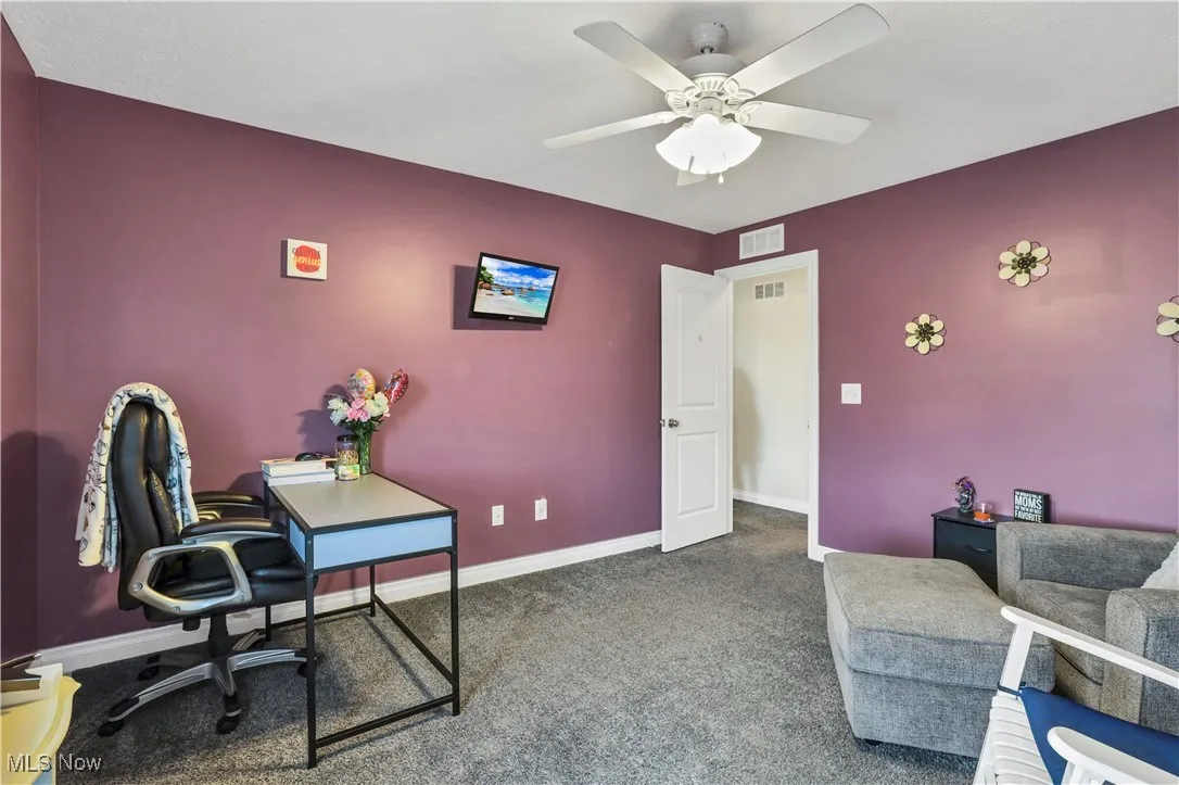 Carpeted office featuring baseboards and ceiling fan