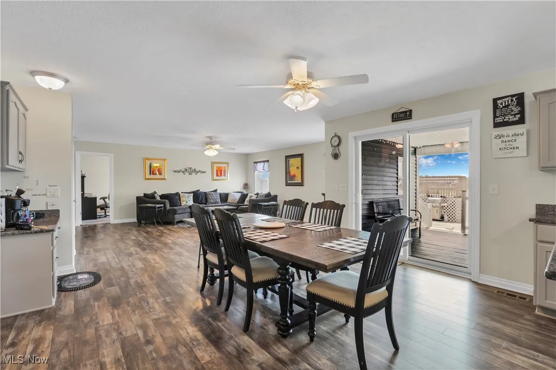 Dining space featuring ceiling fan, dark wood-style flooring, and baseboards