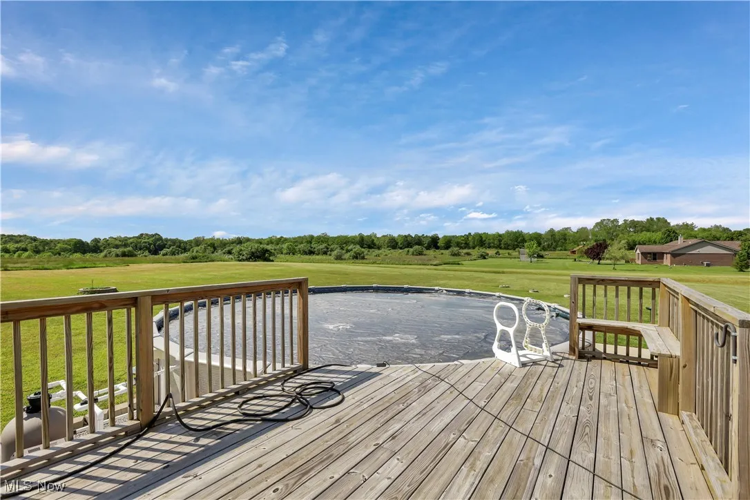 Wooden terrace with a lawn and view of wooded area