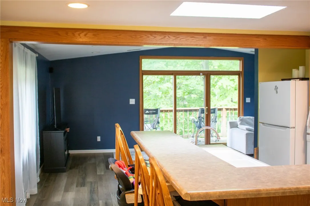 Dining area with wood finished floors, recessed lighting, and a skylight