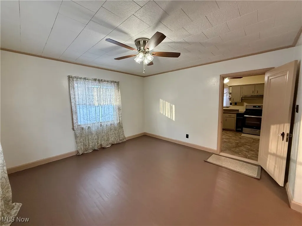 Spare room with ceiling fan and ornamental molding