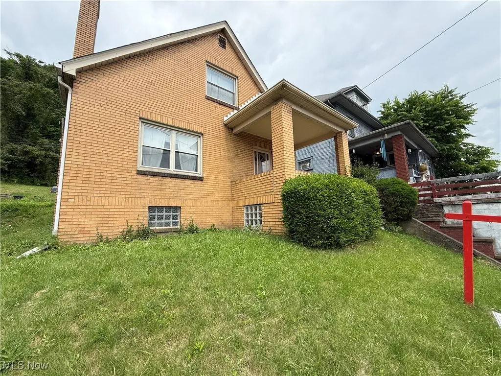 View of home's exterior with brick siding and a chimney
