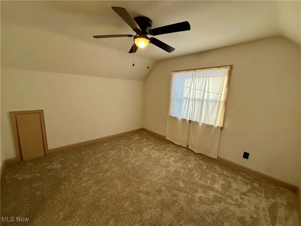 Bonus room featuring ceiling fan, carpet, and vaulted ceiling