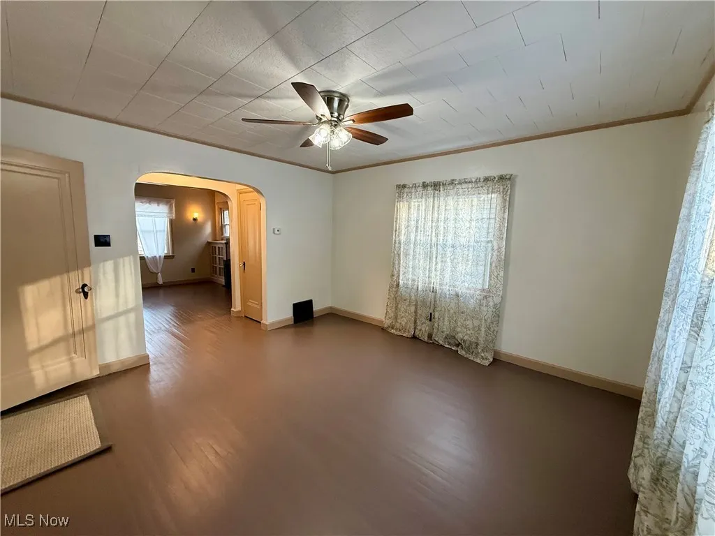 Unfurnished room featuring ceiling fan, crown molding, and wood-type flooring