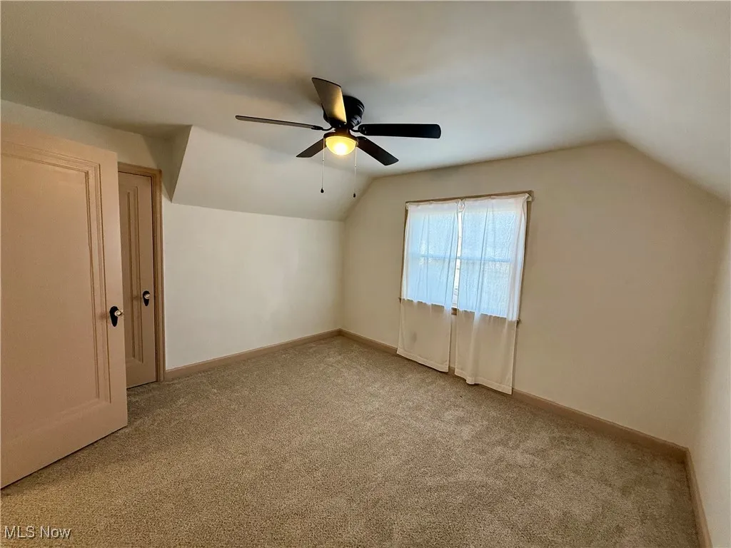 Bonus room featuring ceiling fan, light carpet, and vaulted ceiling