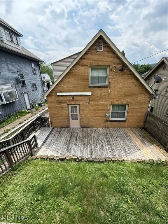 Rear view of house with brick siding and a deck