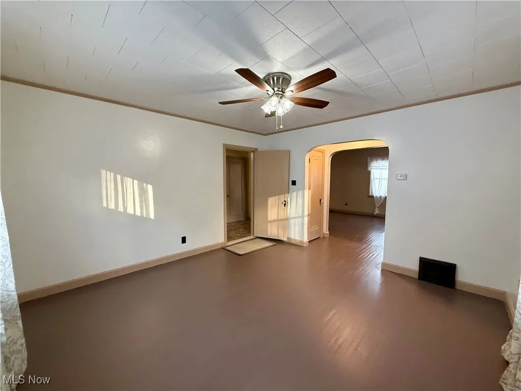 Spare room with ceiling fan and ornamental molding
