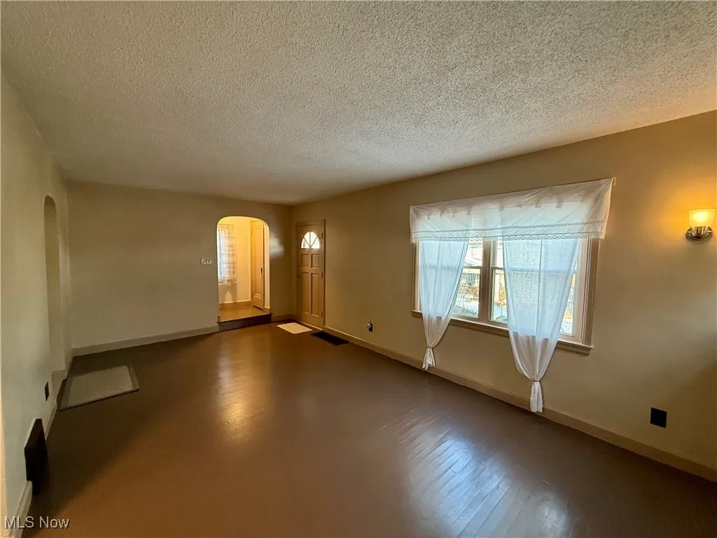 Spare room with a textured ceiling and hardwood / wood-style floors