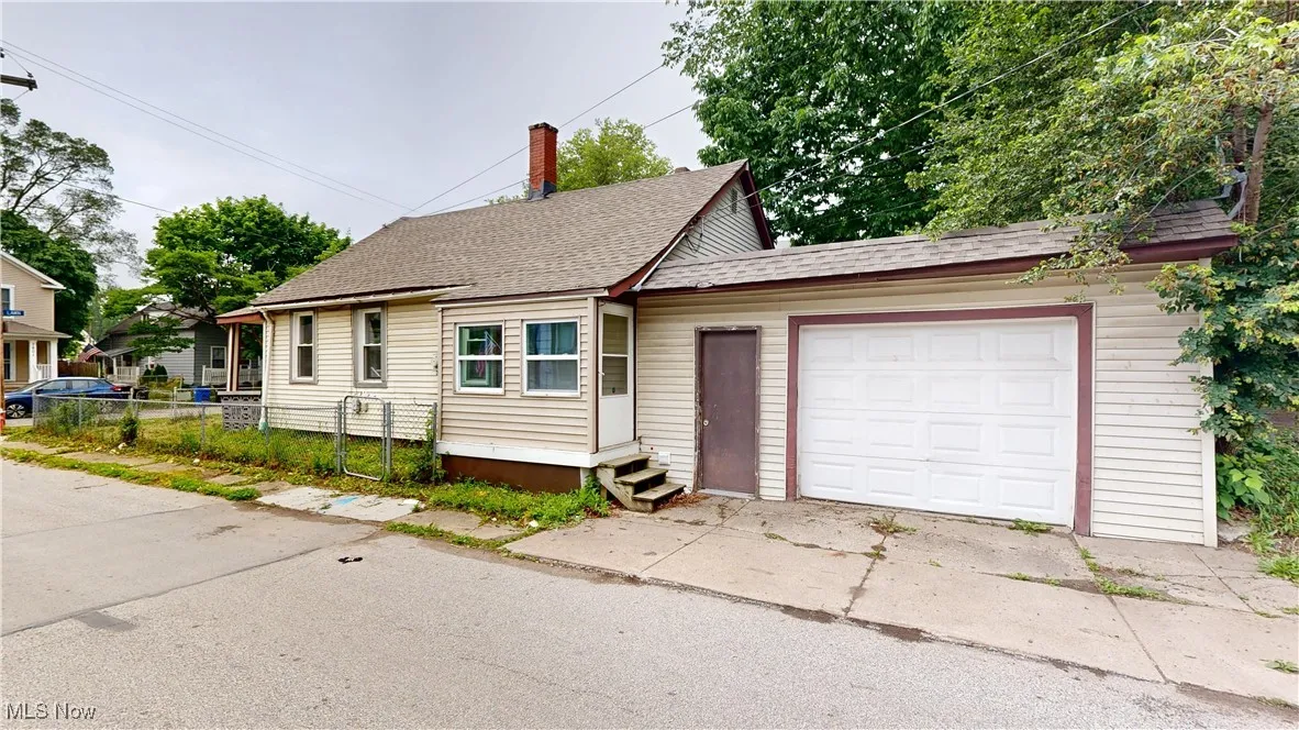 View of front of house featuring a shingled roof, concrete driveway, and an attached garage