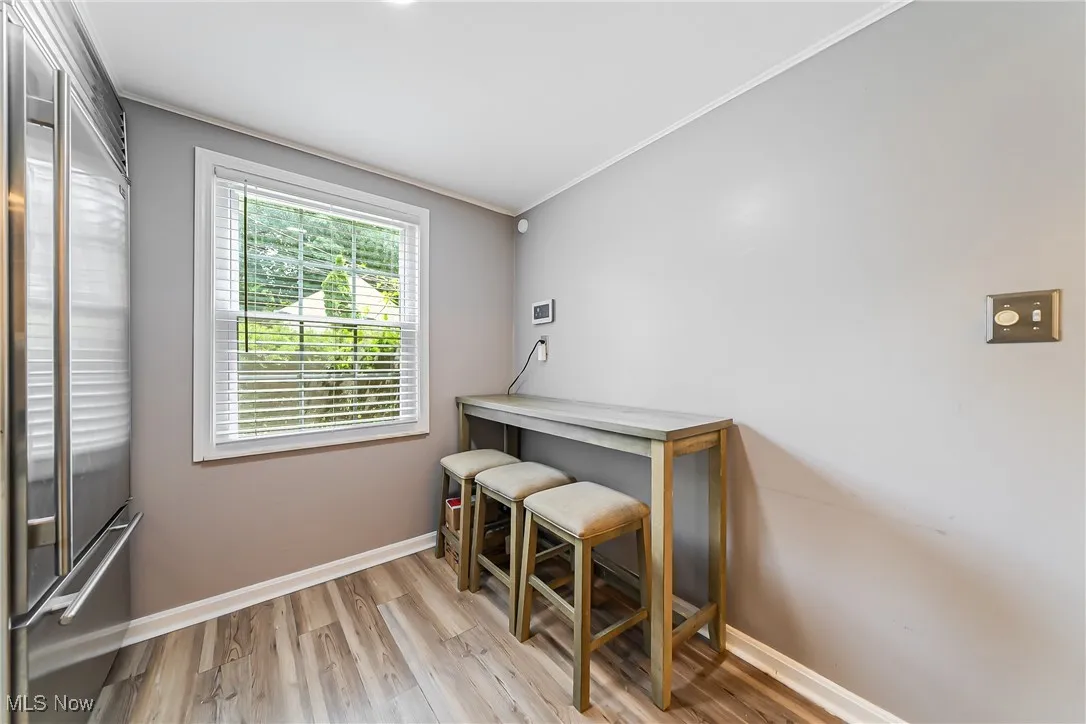 Office space featuring light wood-style flooring and crown molding