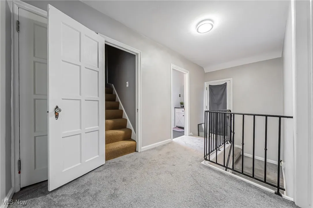 Corridor featuring carpet flooring and an upstairs landing