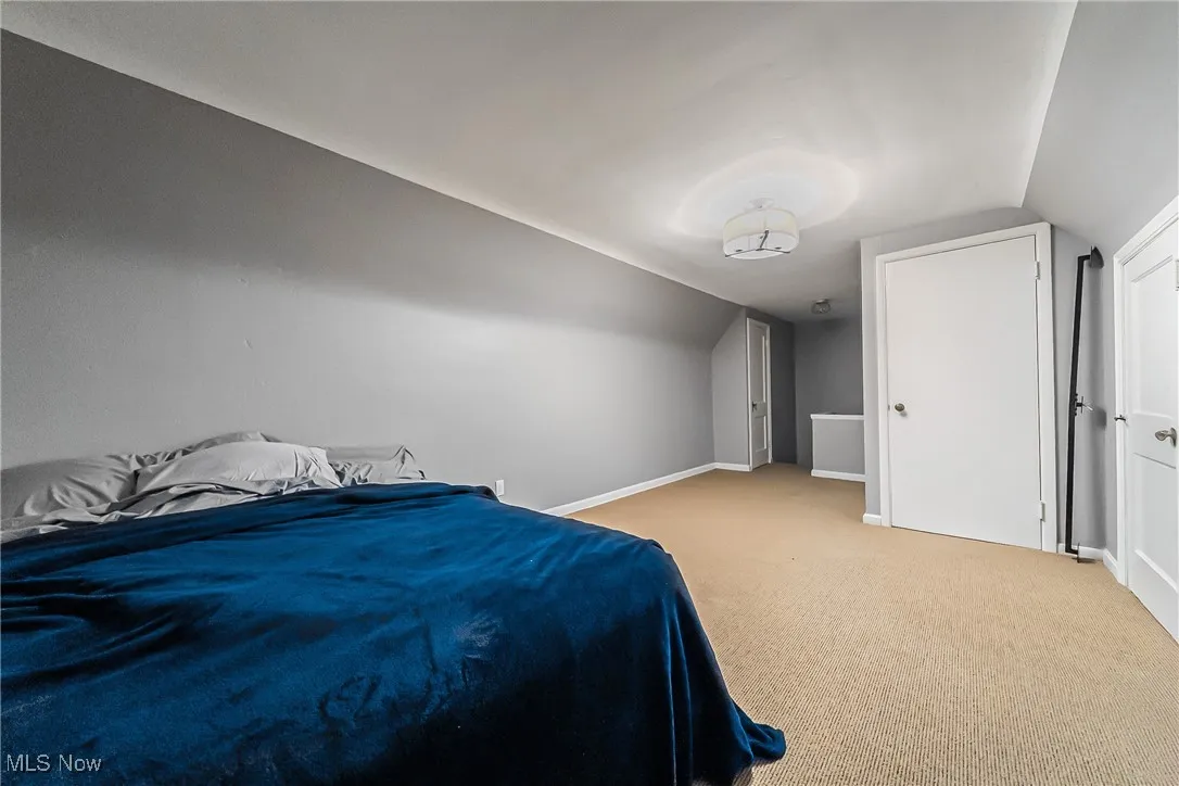 Bedroom featuring lofted ceiling and carpet flooring
