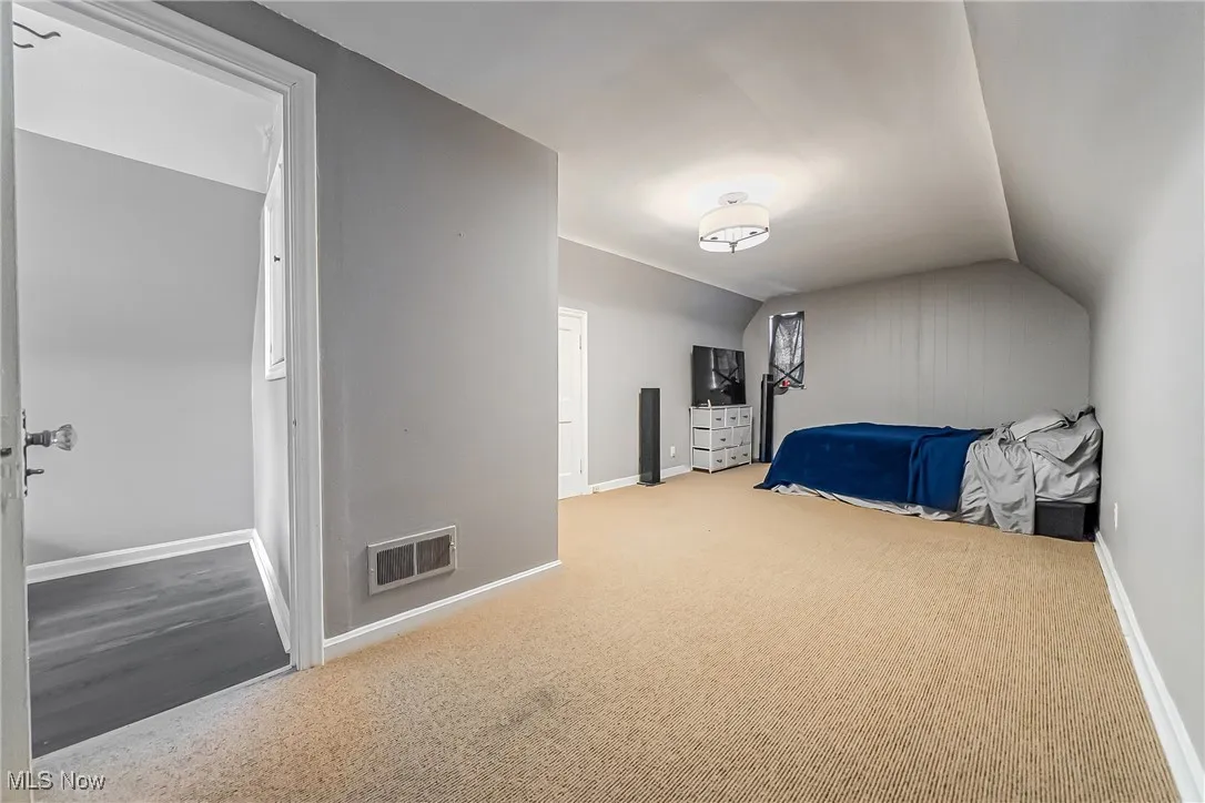 Bedroom with vaulted ceiling and carpet flooring