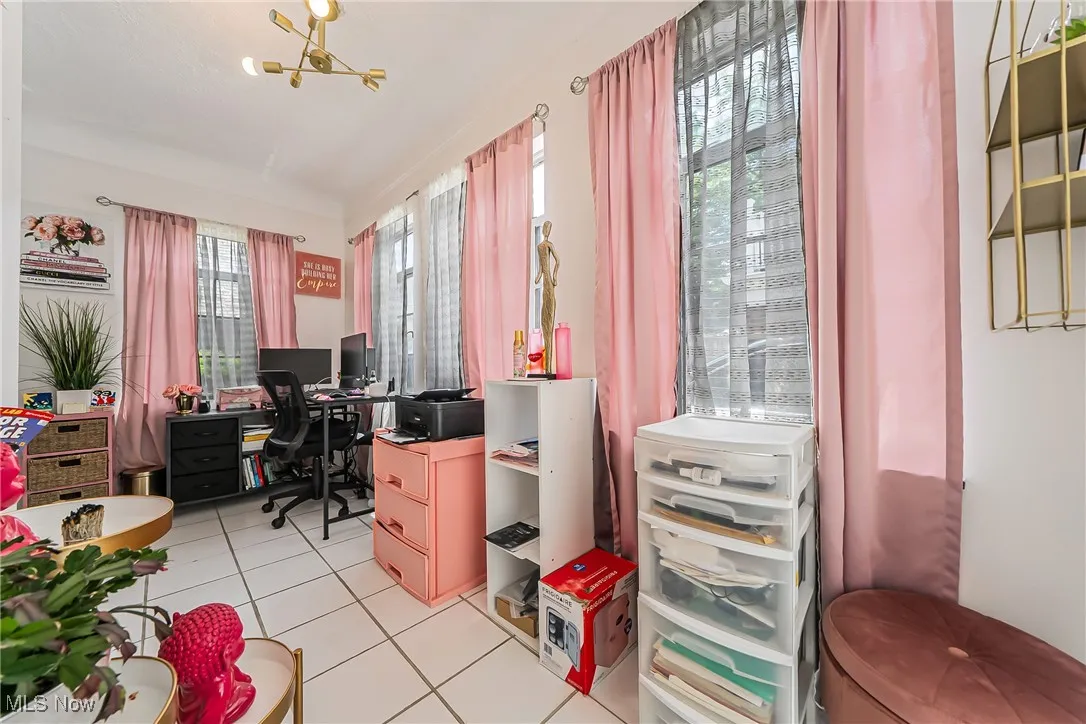Home office with light tile patterned flooring and a chandelier