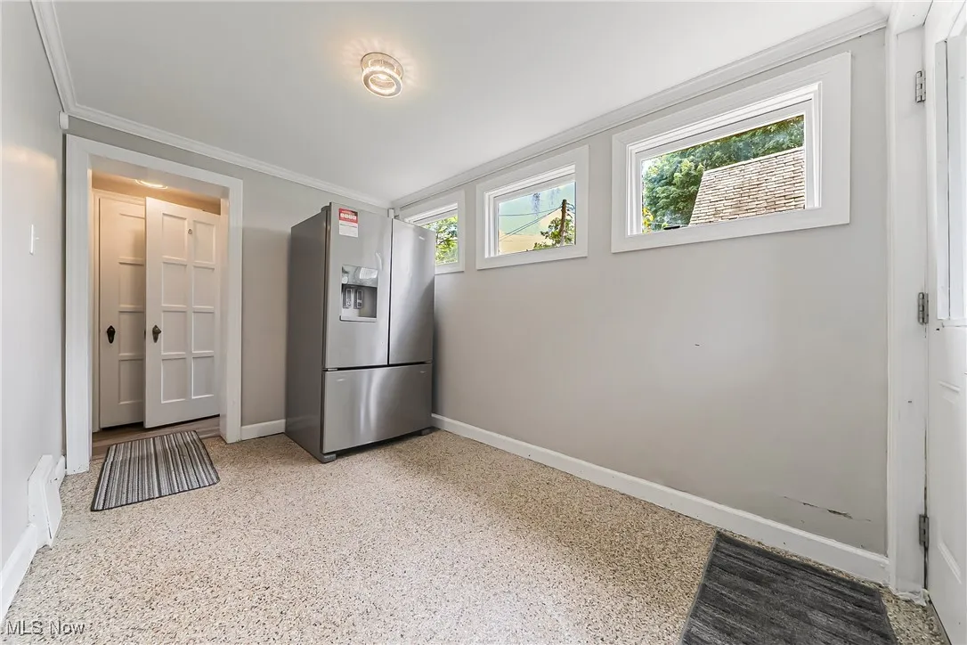 Kitchen featuring stainless steel fridge with ice dispenser and crown molding