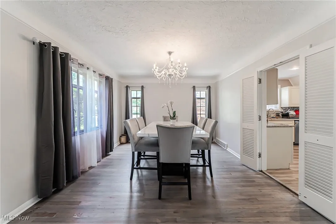 Dining space featuring a chandelier, a textured ceiling, and wood finished floors