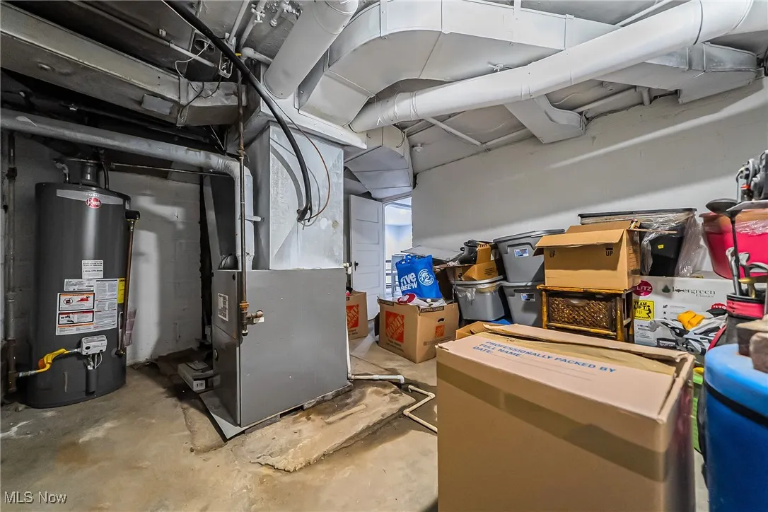 Unfinished basement featuring gas water heater and heating unit