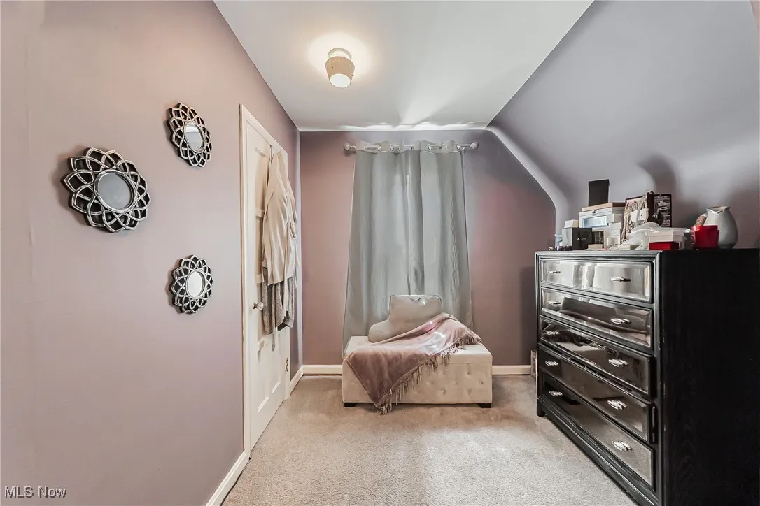 Living area featuring light colored carpet and baseboards