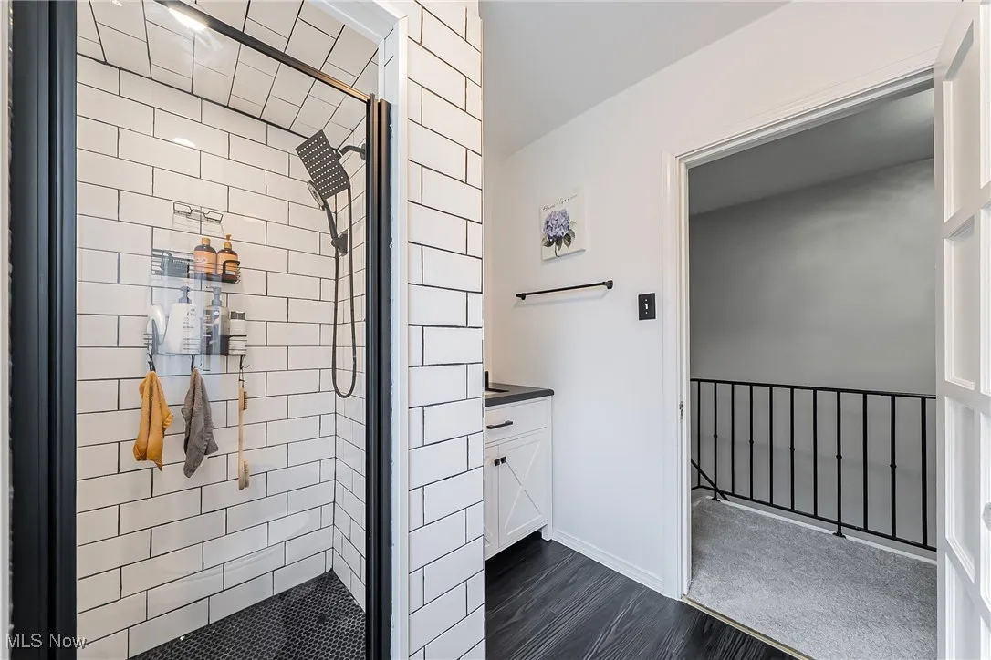 Bathroom with a shower stall, wood finished floors, and vanity