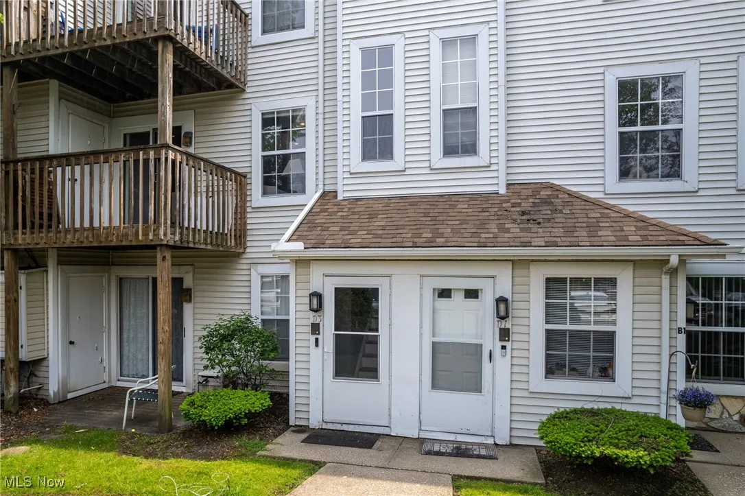 Property entrance featuring a balcony and a shingled roof