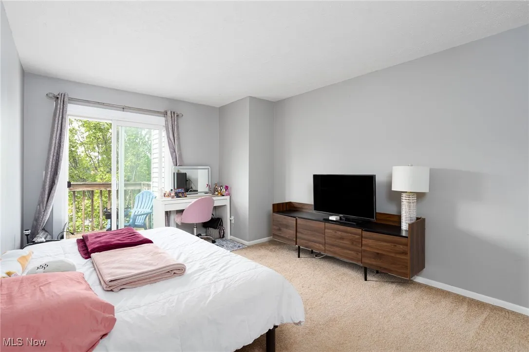 Carpeted bedroom featuring a desk and baseboards