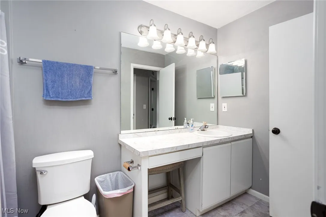 Bathroom with vanity, toilet, and baseboards