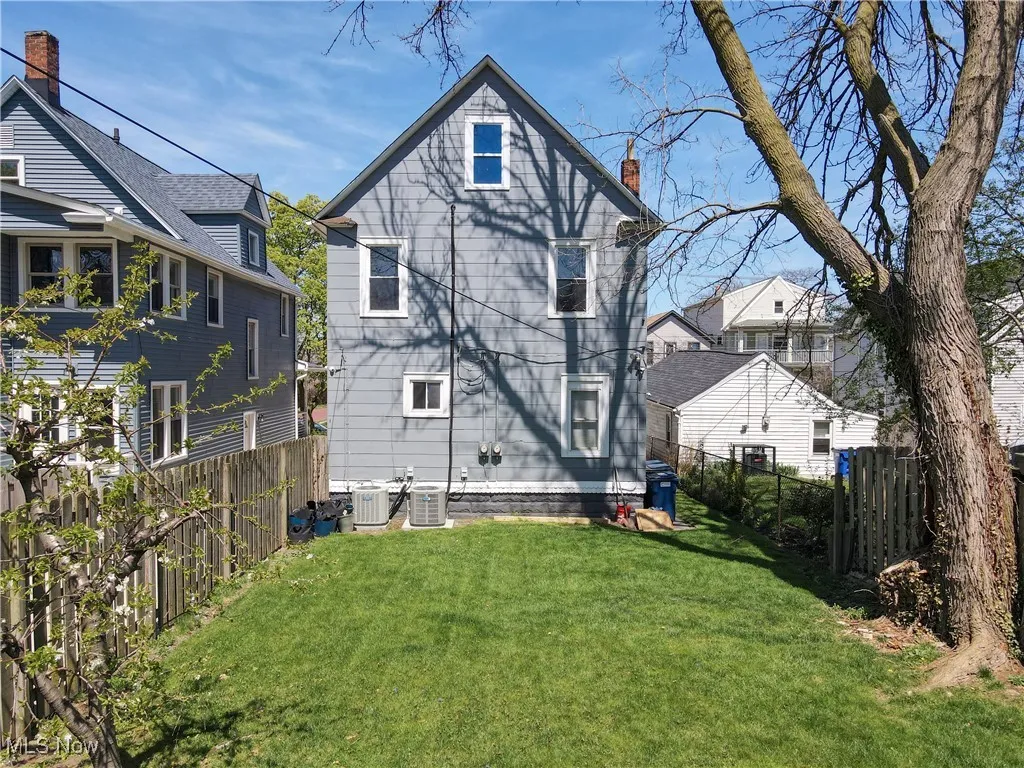 Back of property with central air condition unit and a chimney