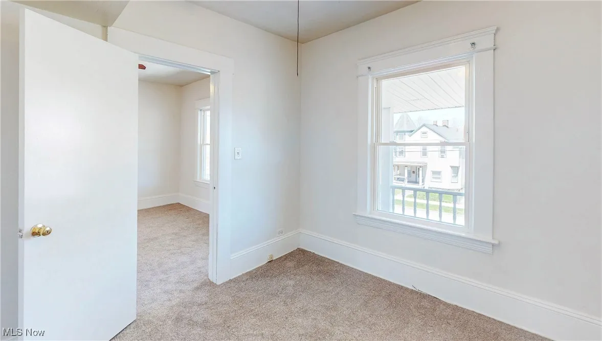 Unfurnished room with carpet floors and baseboards