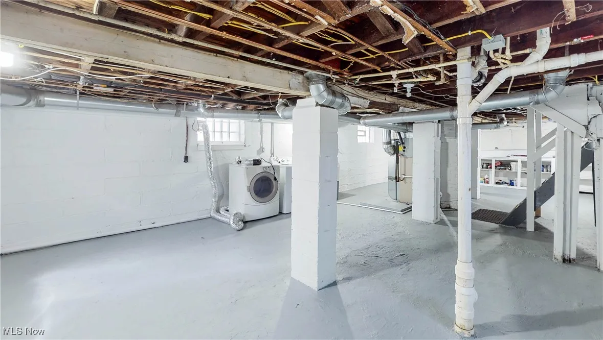 Below grade area featuring washer and clothes dryer and heating unit
