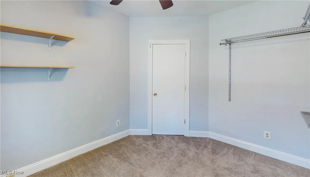 Unfurnished bedroom featuring carpet, baseboards, and a ceiling fan