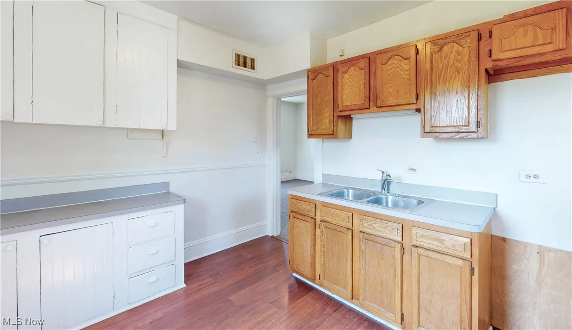Kitchen featuring a sink, light countertops, and dark wood-style flooring