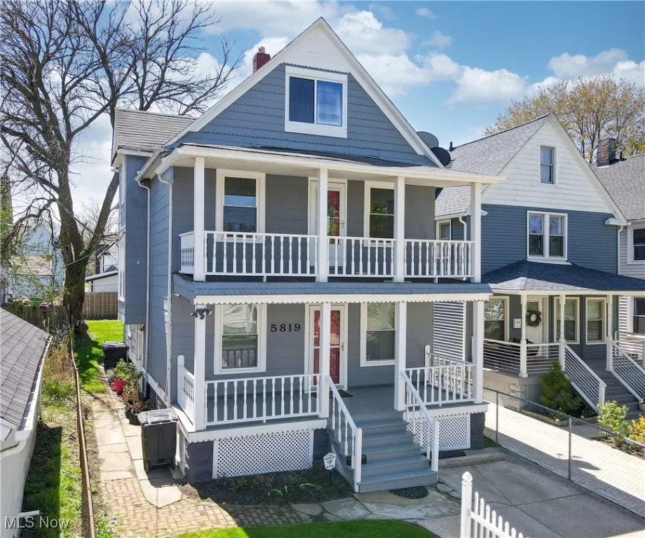 View of front of home with covered porch, a balcony, and a chimney