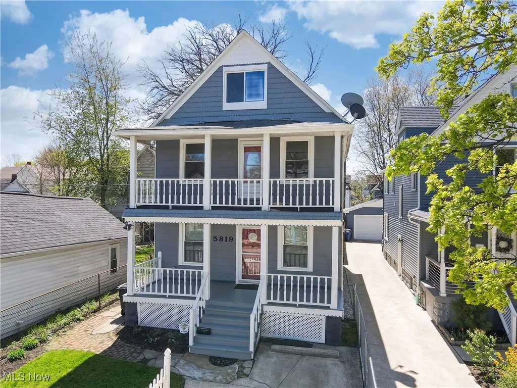 View of front of home featuring covered porch, an outbuilding, a detached garage, and a balcony