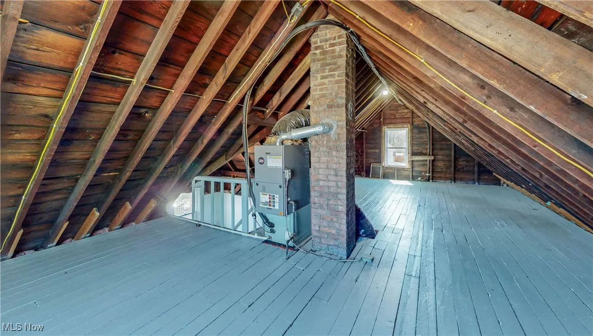 Unfinished attic with an upstairs landing
