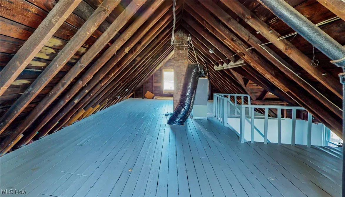 Unfinished attic featuring an upstairs landing