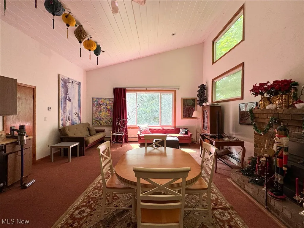 Dining room featuring carpet flooring, ceiling fan, high vaulted ceiling, and wooden ceiling