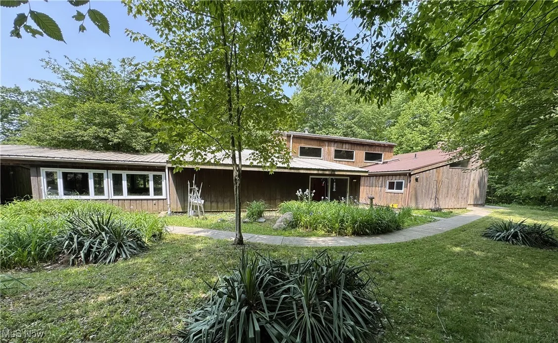 Back of property with a yard and metal roof