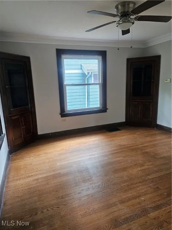 Spare room featuring ornamental molding, wood finished floors, and ceiling fan